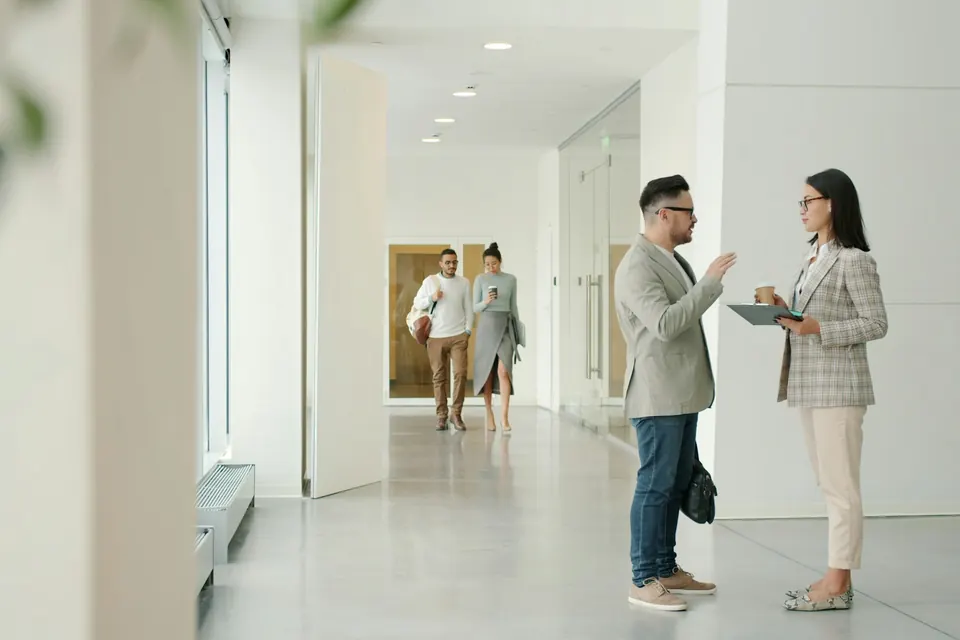 Dos agentes inmobiliarios conversando en una vivienda luminosa