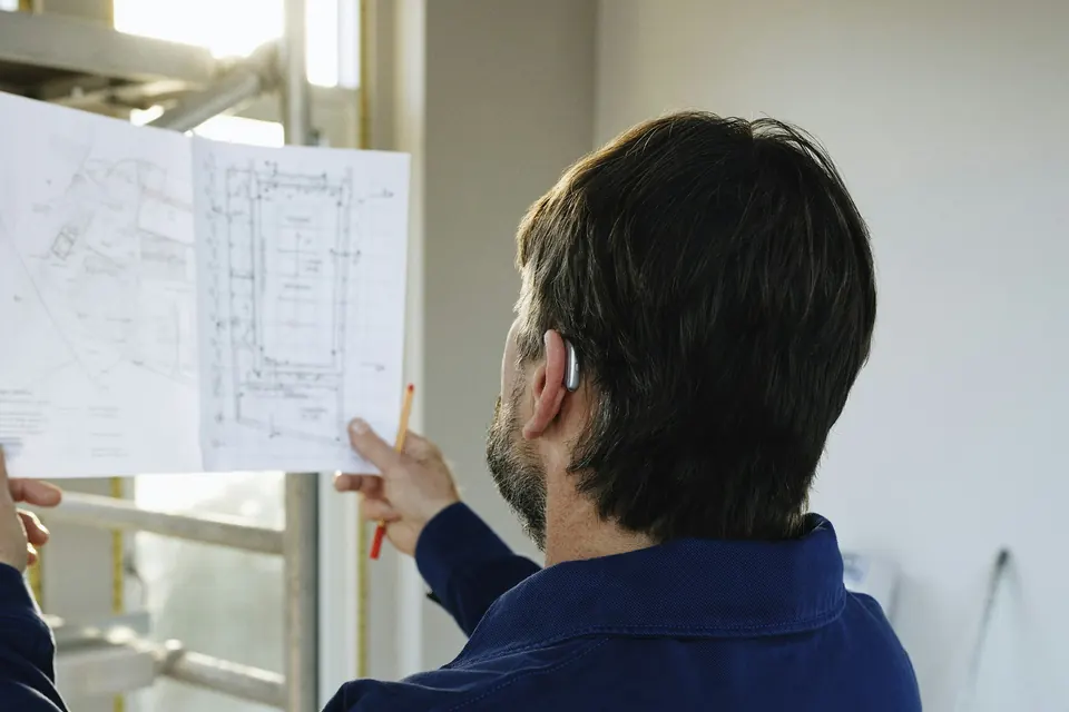 Profesional revisando planos en una obra